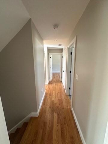 hall with baseboards and light wood-style flooring