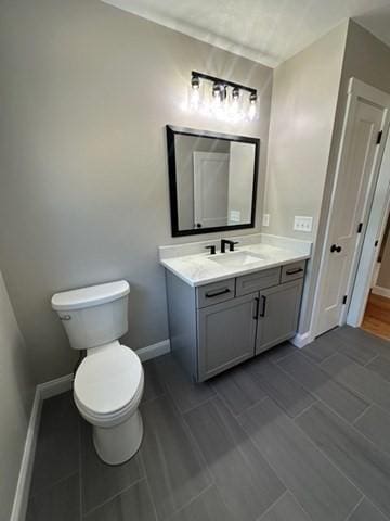 bathroom with vanity, toilet, and baseboards
