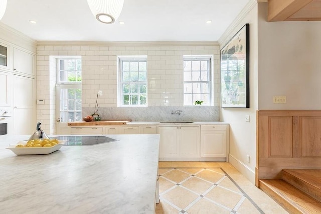 kitchen featuring sink, backsplash, light tile patterned floors, and crown molding