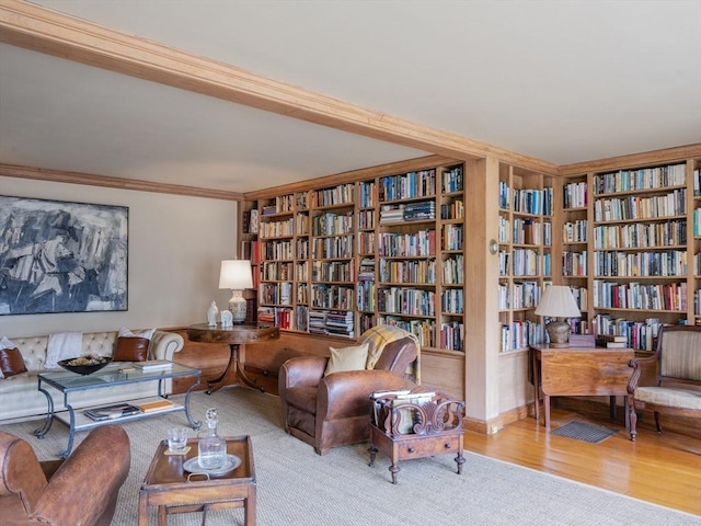 sitting room featuring crown molding, built in features, and light hardwood / wood-style floors