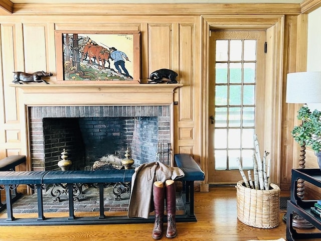 living area with crown molding, a fireplace, plenty of natural light, and wooden walls