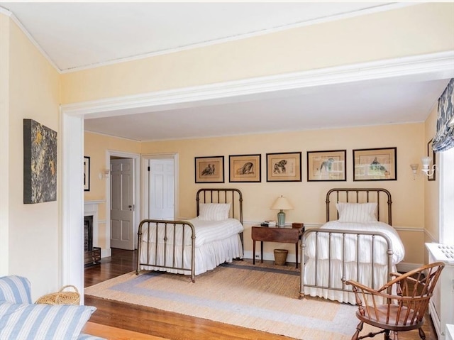 bedroom with hardwood / wood-style flooring and radiator heating unit