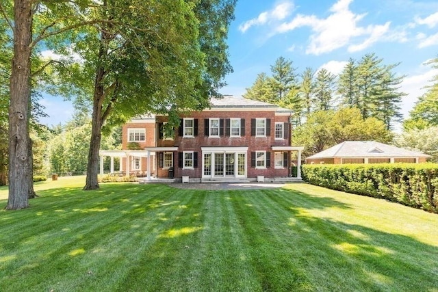 back of property featuring a lawn and a patio