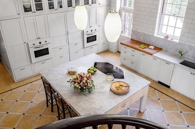 kitchen featuring white cabinets, light tile patterned floors, and oven