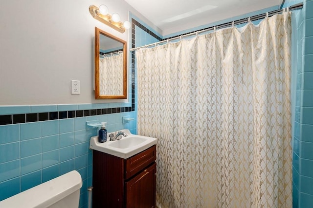 bathroom featuring toilet, tile walls, vanity, and a shower with curtain