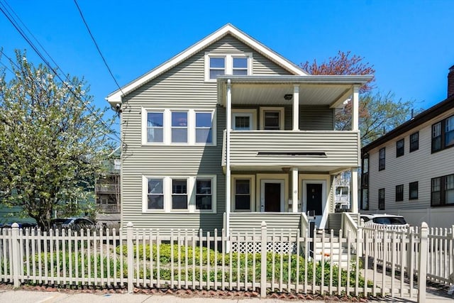 view of front of property with a balcony, a fenced front yard, and a porch