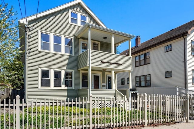 view of front of property featuring a balcony, fence, and covered porch