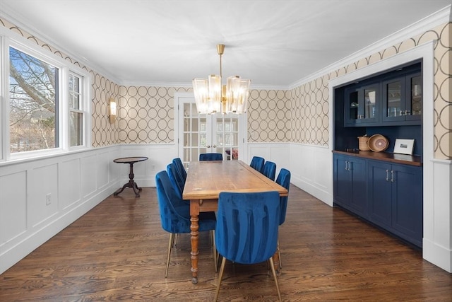 dining area featuring wallpapered walls, dark wood-style floors, and wainscoting