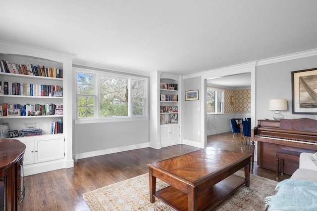 living area featuring built in features, a healthy amount of sunlight, ornamental molding, and wood finished floors