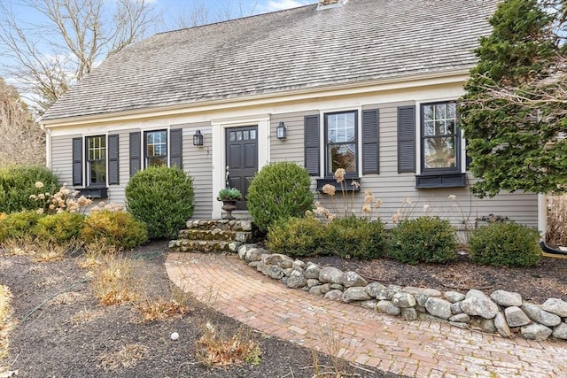 new england style home featuring a chimney