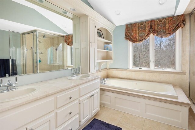 full bath featuring tile patterned flooring, a shower stall, a bath, and a sink