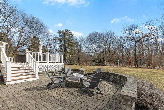 view of patio / terrace with a wooden deck, stairway, and a fire pit