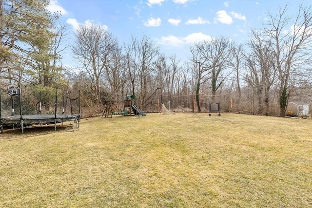 view of yard with a trampoline and a playground