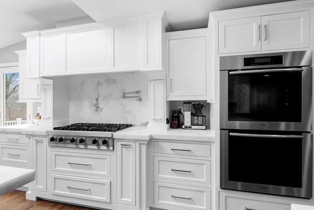 kitchen featuring backsplash, white cabinetry, and stainless steel appliances