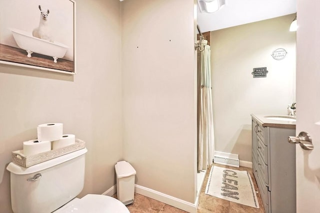 full bathroom featuring toilet, baseboards, and vanity