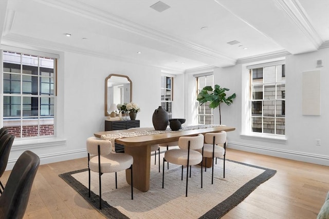 dining area featuring light wood-type flooring, a wealth of natural light, and crown molding