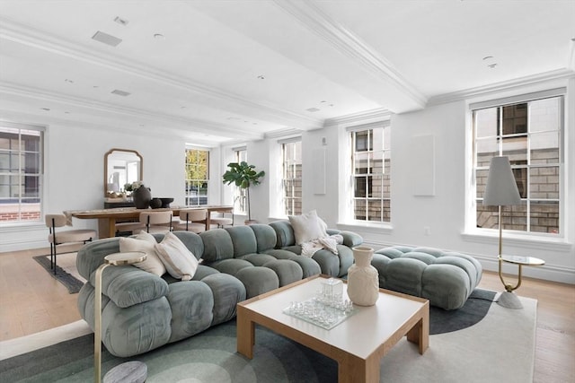 living room with beamed ceiling, ornamental molding, and light hardwood / wood-style flooring