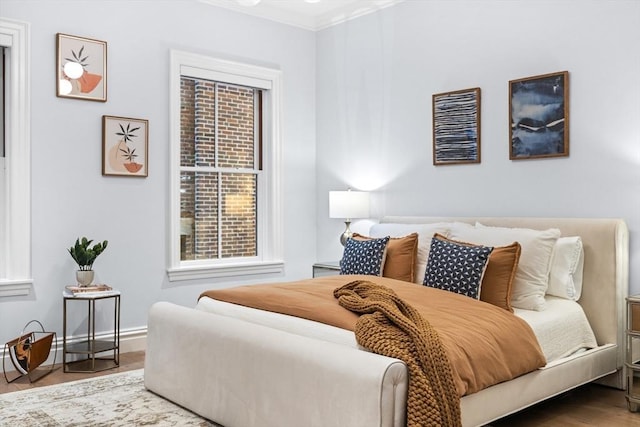 bedroom with hardwood / wood-style flooring and ornamental molding