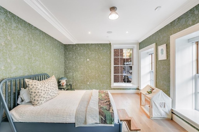 bedroom featuring baseboard heating, crown molding, and light hardwood / wood-style flooring