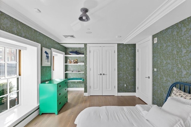 bedroom featuring baseboard heating, ornamental molding, and wood-type flooring