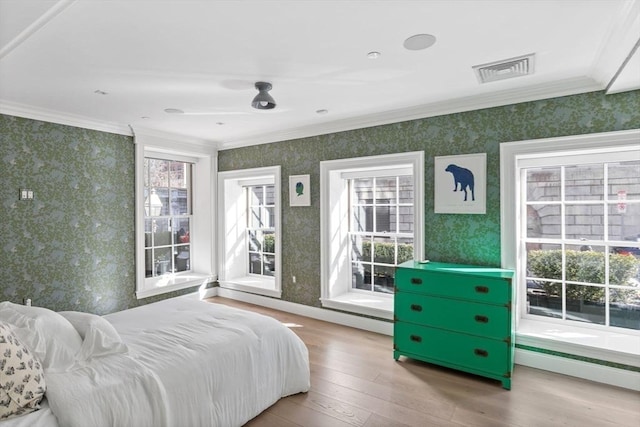 bedroom featuring ceiling fan, ornamental molding, and light hardwood / wood-style flooring