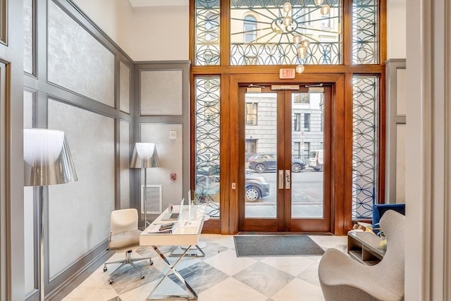 entryway featuring french doors and a towering ceiling