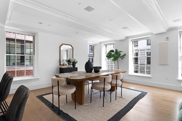 dining space featuring light hardwood / wood-style floors, ornamental molding, and a healthy amount of sunlight