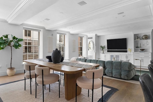 dining space featuring ornamental molding, hardwood / wood-style floors, and built in shelves