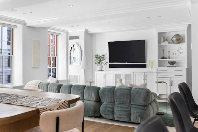 living room with light wood-type flooring and crown molding