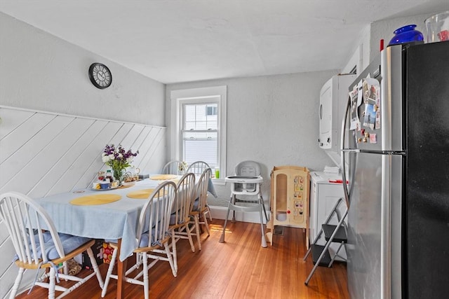 28 Gardner St, Arlington, MA 02474 - dining space with stacked washer / dryer, wood finished floors, and a wainscoted wall