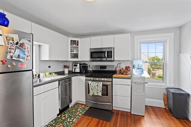 28 Gardner St, Arlington, MA 02474 - kitchen with appliances with stainless steel finishes, wood finished floors, white cabinetry, and glass insert cabinets