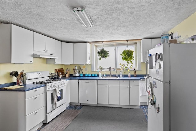28 Gardner St, Arlington, MA 02474 - kitchen with white appliances, a sink, dark countertops, under cabinet range hood, and white cabinetry