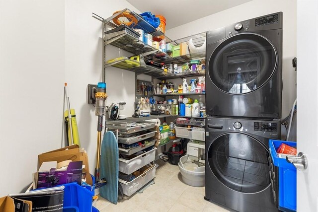 washroom featuring light tile patterned floors and stacked washer / dryer