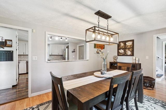 15 Bunny Ln, Brooklyn, CT 06234 - dining room with light wood-style flooring, baseboards, a textured ceiling, and rail lighting