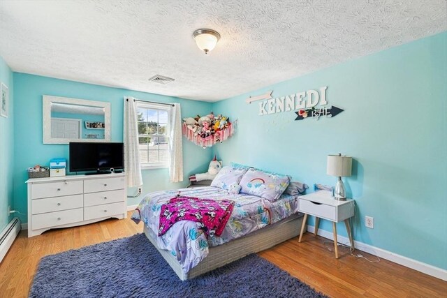 15 Bunny Ln, Brooklyn, CT 06234 - bedroom with a textured ceiling, wood finished floors, baseboards, and a baseboard radiator