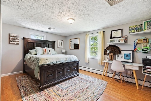 15 Bunny Ln, Brooklyn, CT 06234 - bedroom with wood finished floors, baseboard heating, baseboards, and a textured ceiling