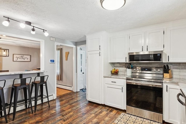 15 Bunny Ln, Brooklyn, CT 06234 - kitchen with stainless steel appliances, a baseboard radiator, dark wood-style floors, backsplash, and a textured ceiling