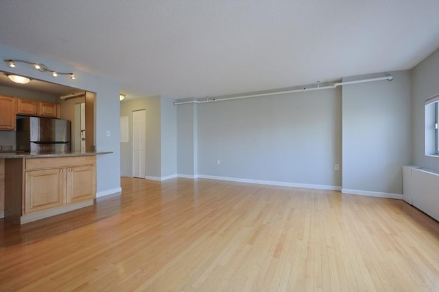 872 Massachusetts Ave Unit 401, Cambridge, MA 02139 - unfurnished living room with light wood-style floors and baseboards