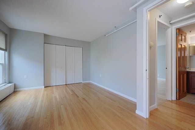 872 Massachusetts Ave Unit 401, Cambridge, MA 02139 - unfurnished bedroom with light wood-style flooring, a closet, and ensuite bath