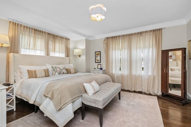 bedroom featuring multiple windows, crown molding, and wood finished floors