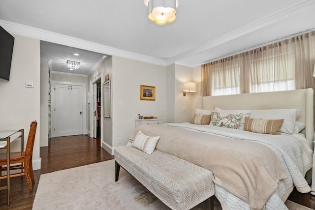 bedroom featuring ornamental molding, baseboards, and wood finished floors