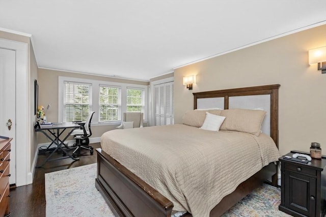 bedroom with ornamental molding, wood finished floors, and baseboards