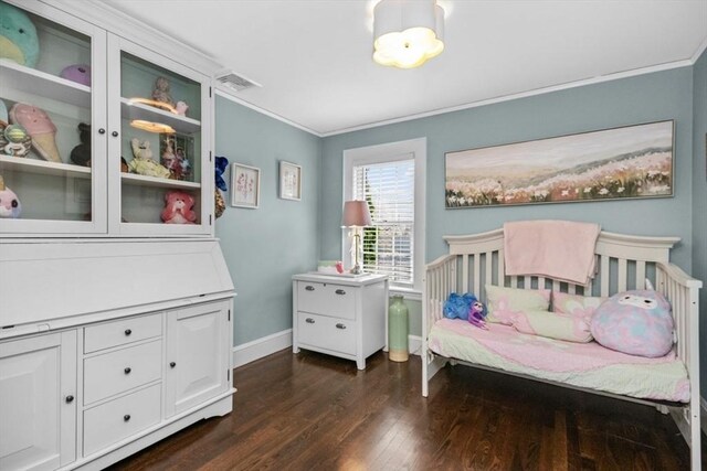 bedroom featuring ornamental molding, dark wood-style floors, and baseboards