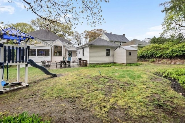 back of house with a yard and a patio area