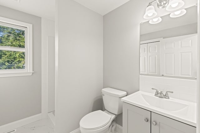 bathroom featuring decorative backsplash, vanity, and toilet