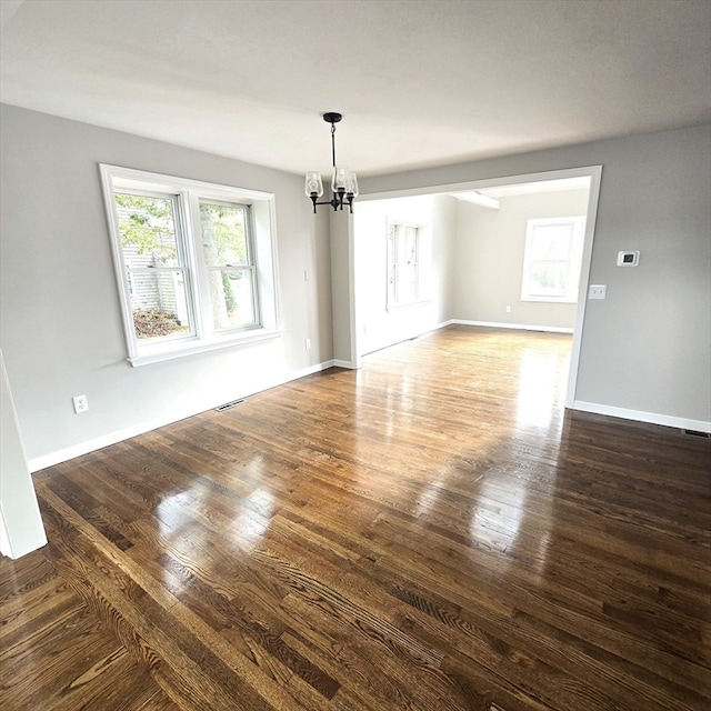 interior space with an inviting chandelier and dark hardwood / wood-style flooring