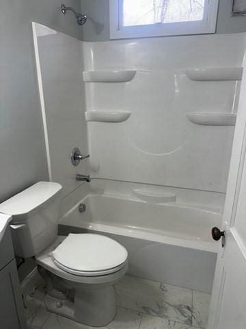 bathroom with shower / bathing tub combination, vanity, toilet, and marble finish floor
