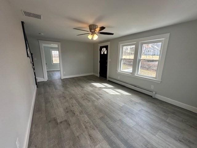 unfurnished living room featuring visible vents, ceiling fan, baseboard heating, baseboards, and wood finished floors