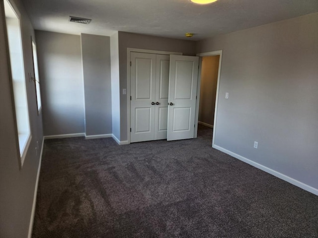 53 Kelly Ln, Lynn, MA 01904 - unfurnished bedroom with baseboards, dark colored carpet, and visible vents
