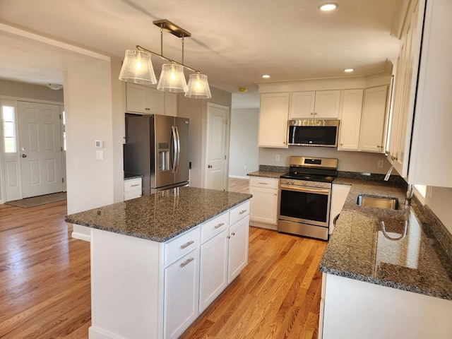 53 Kelly Ln, Lynn, MA 01904 - kitchen featuring dark stone counters, appliances with stainless steel finishes, white cabinets, and light wood-type flooring